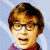 Pixelated portrait of a person with short brown hair, glasses, and light skin against a blue background.