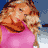 Pixelated static image of a person with light brown hair wearing a pink top against a blue background.