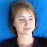 A person with light brown hair and a black top against a blue background appears in three showing subtle facial expression changes