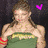 A woman in a green strapless top with yellow text, wearing red bracelets and a purple heart symbol above her head.