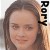 A pixelated close-up of a person with long brown hair, a neutral expression, and visible eyes and nose, with vertical text on the right side.