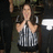 Pixelated image of a person in striped shirt with hands clasped near chest, dark background.