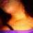 A pixelated close-up of a person's neck and shoulder area with a purple garment, showing subtle motion in the upper body.