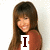 A woman with long brown hair and bangs wears a rust-colored top against a light background, with text overlays changing across frames.