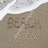 Static beach scene with sand, ocean waves, and palm trees under a blue sky.