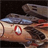 A pixelated image of a mechanical vehicle with a red circular emblem on its side, set against a dark background.