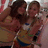 Two figures in close embrace, one with dark hair and the other with lighter brown hair, wearing a yellow top with blue accents.
