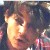 Pixelated close-up of a person's face with warm-toned skin, dark hair, and a blurred background of indistinct colors.