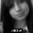 A grayscale pixelated image of a person with long dark hair, wearing a light-colored top and holding an object near their shoulder.