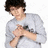 Pixelated image of a person in a light gray long-sleeve shirt holding a microphone, with text elements on a light blue background.