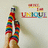 A pixelated image shows a figure in rainbow-colored clothing holding a white object, with 'UNKHUI' text and red-yellow shapes above.