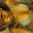 Pixelated image of a cartoon character with large eyes and brown hair, wearing a light-colored top against a warm-toned background.