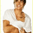 Pixelated image of a person in a white shirt with brown hair, seated with arms crossed against a light background.