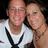 Two people pose closely together in a pixelated image; one wears a white shirt with black accents, the other has light brown hair.
