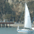 A static pixelated image shows a sailboat on water with a dock and trees in the background, rendered in muted blues, browns, and grays.