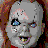 Pixelated image of a doll's face with gray skin, blue eyes, and red hair next to bold red text reading 'Chucky wants to PLAY!' on black background.