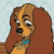 Pixelated cartoon dog with long brown ears, orange face stripe, black nose, white eyes, and blue collar against light background.