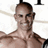 A split-screen image with a shirtless man on the left, 'John Rivers' text in black boxes on gray background top-right, and red 'M31 In 2009' text on black bottom-left.