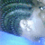Pixelated image of a blue-toned scene with dark green and teal foliage on the left, transitioning to light gray and white areas on the right against a pale blue background.