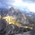 A pixelated image shows a golden object with a reflective surface against a blurred background of blue and gray tones.
