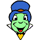 Green cartoon character with blue turban and yellow bow tie, smiling broadly with open mouth showing red tongue.
