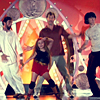 Four people pose together on a stage with a red and orange background featuring circular light patterns.