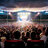 A pixelated image of a theater interior with rows of seats and a bright screen displaying light patterns.