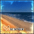 Pixelated beach scene with blue sky, dark water, and sandy shore featuring orange-brown terrain and scattered light-colored patches.
