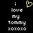Black background with white pixelated text reading "i love my tommy xoxoxo" and a yellow heart symbol above the word "love".
