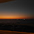 Pixelated static image of a sunset over water with horizontal bands of orange, yellow, and dark blue hues.
