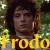 Pixelated image of a person with dark hair and a neutral expression, overlaid with large yellow text reading "Frodo" against a blurred green background.