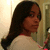 A person with long dark hair in a side ponytail wears a light-colored top, facing left then right across four