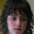 A person with dark curly hair and light skin appears in four showing subtle facial expression changes against a yellow and white background