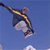 Pixelated static icon of a figure skiing with yellow and black equipment against blue background, showing motion blur on limbs and gear.