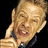 Pixelated close-up of a person with light hair, hand near face, wearing dark clothing against black background.