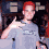 A pixelated image of a person with red hair wearing a gray shirt, making a hand gesture in two and displaying text on the right