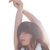 A person with dark hair in a white top performs a side stretch with one arm extended overhead and the other resting on their head, set against a plain white background.