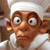 Pixelated image of a character with brown skin, large white eyes with black pupils, and a white head covering, wearing a white garment against a brown background.