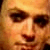 Pixelated close-up of a person's face showing eyes, nose, and mouth with warm orange and brown tones.