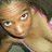 Pixelated close-up of a person with light skin, dark eyes, and short hair resting their chin on one hand against a blurred background.