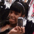 A person wearing a black cap with white stripes holds a silver flip phone, captured in a four- with subtle pose changes