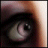 A pixelated close-up of a single eye with visible eyelashes and iris details, set against a gradient background transitioning from dark brown to light beige.