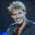 Pixelated static image of a person with light-colored hair and dark clothing against a dark background, rendered in low-resolution 256x256 pixels.