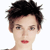 Pixelated close-up of a person's face with short dark hair, light skin, and red lips against a white background.