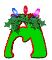 Green letter M with red outline, holly leaves, and three colored lights (blue, red, pink) on top; animation cycles through light states.