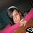 Pixelated image of a person with dark hair wearing pink clothing, holding an object against a dark background.