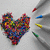 A four-quadrant image with a heart made of colored dots, crayons on the top-left background, and text in blue and green boxes.