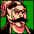 Pixelated static icon of a bearded man with glasses and long hair, wearing a sleeveless top against a green background.