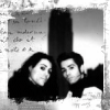 Black-and-white image of two people in profile, one with long dark hair and the other with short dark hair, positioned side-by-side against a textured background.