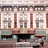 A pixelated static image of a building facade with columns and decorative architectural details in muted tones.